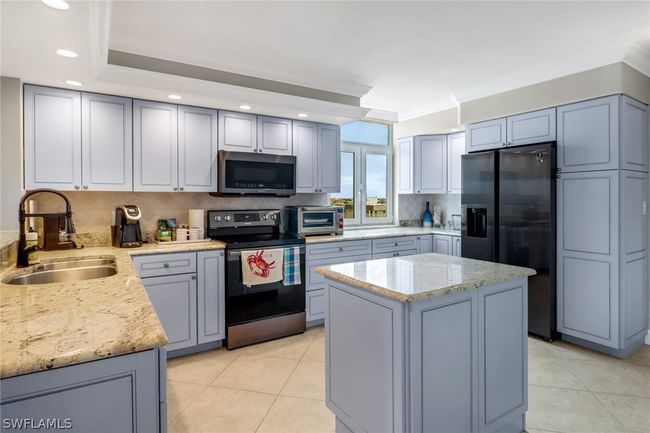 Kitchen featuring appliances with stainless steel finishes, tasteful backsplash, sink, light tile flooring | Image 6
