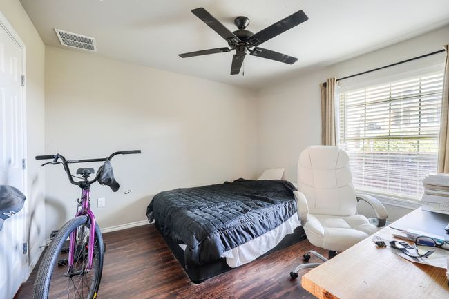 Bedroom featuring a ceiling fan, wood finished floors, visible vents, and baseboards | Image 14