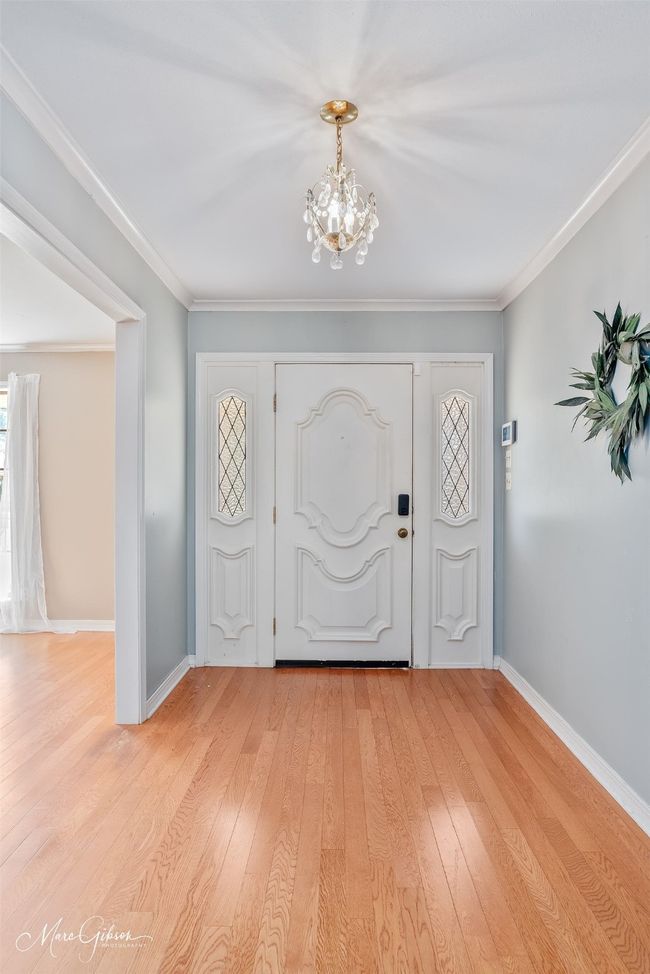 Entryway with light wood-style flooring, baseboards, an inviting chandelier, and ornamental molding | Image 4