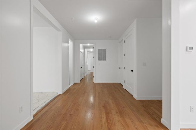 Hallway featuring light wood-style flooring and baseboards | Image 6