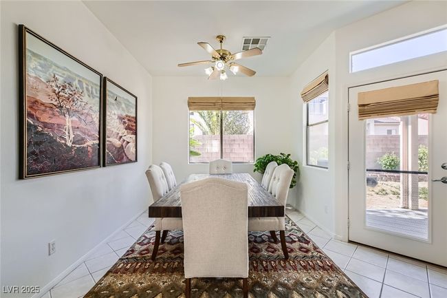 Dining room with healthy amount of natural light, light tile patterned floors, and ceiling fan | Image 12