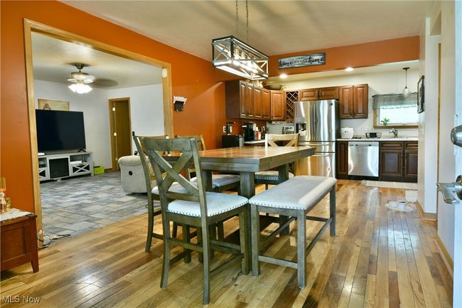Dining space featuring light wood-style flooring and a ceiling fan | Image 7