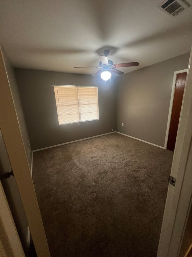 Carpeted empty room featuring a ceiling fan and baseboards | Image 6