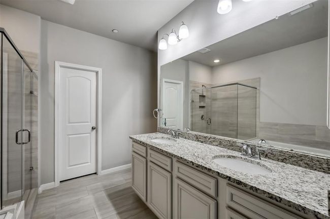 Modern primary bathroom with dual sinks and granite countertops | Image 16