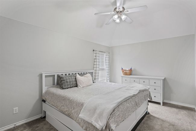 Bedroom with dark carpet, ceiling fan, and vaulted ceiling | Image 29