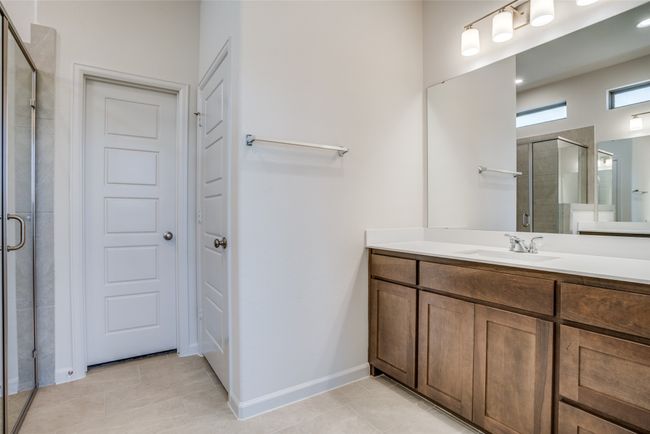 Bathroom featuring a shower stall, vanity, and tile patterned floors | Image 16