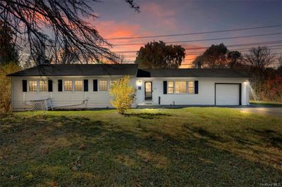 Ranch-style house featuring a lawn and a garage. | Image 1