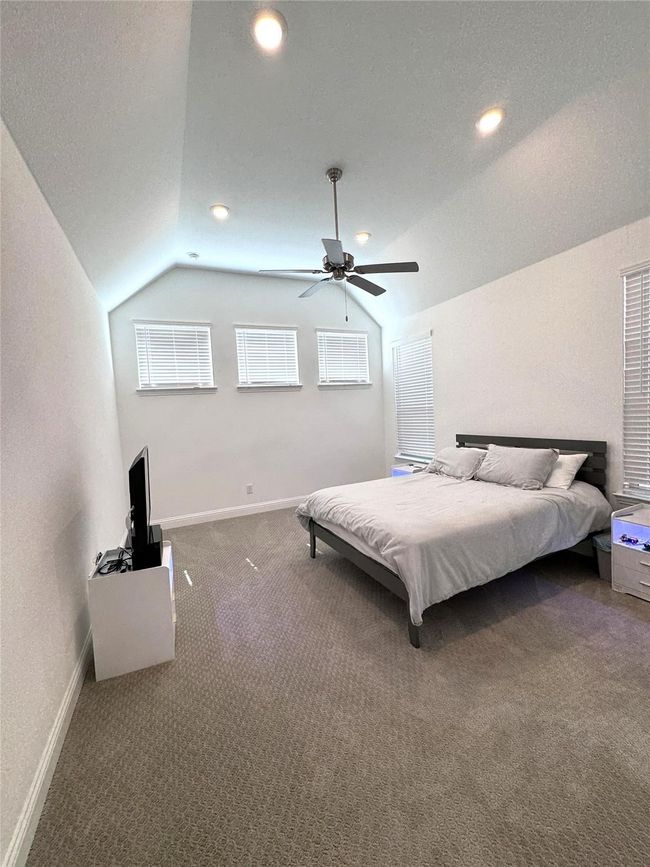 Bedroom featuring vaulted ceiling, carpet flooring, a ceiling fan, and recessed lighting | Image 9