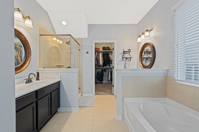 Full bath featuring a spacious closet, a shower stall, a garden tub, and vanity | Image 17