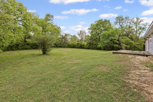 View of grassy yard featuring view of wooded area | Image 30