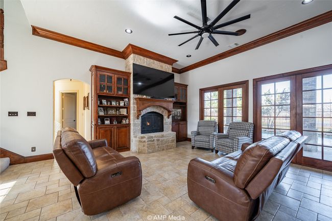 Living room featuring ceiling fan, ornamental molding, and a fireplace | Image 11