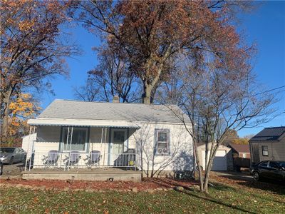 View of front of home with a porch, a garage, and an outdoor structure | Image 3