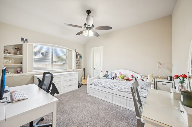 Bedroom featuring light colored carpet, ceiling fan, and lofted ceiling | Image 17