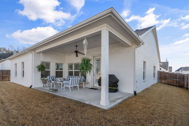 Back of house featuring a ceiling fan, a patio, fence, and brick siding | Image 24