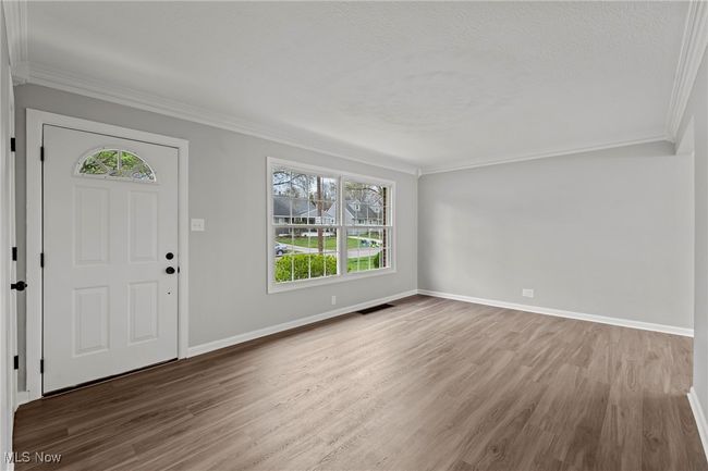 Foyer featuring ornamental molding, visible vents, wood finished floors, and baseboards | Image 9