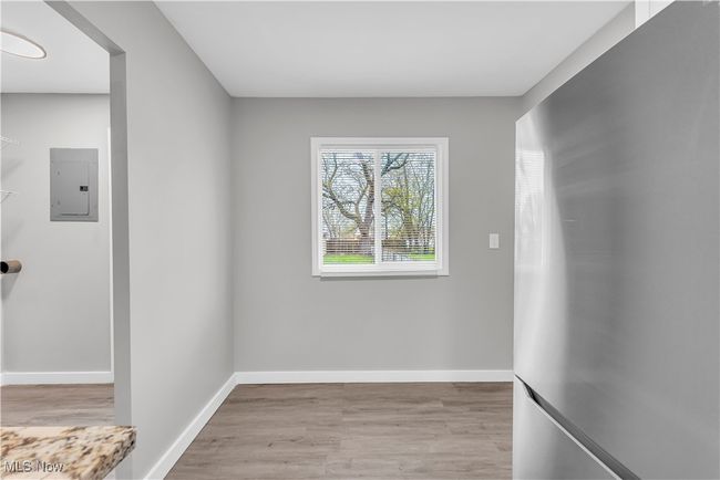 Empty room with wood finished floors, electric panel, and baseboards | Image 9