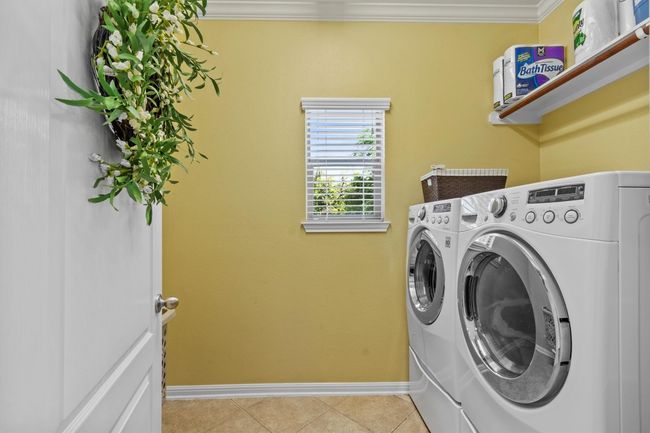 A cheerful laundry space with room to fold, sort, and store—made better with natural light and built-in shelving. | Image 35