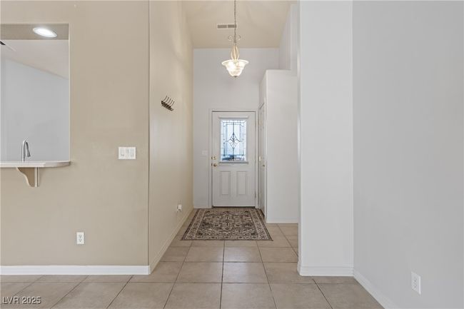 Entrance foyer featuring light tile patterned floors and a towering ceiling | Image 8