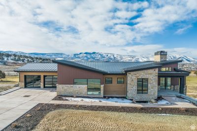 Contemporary house featuring a mountain view, a garage, and a patio area | Image 3