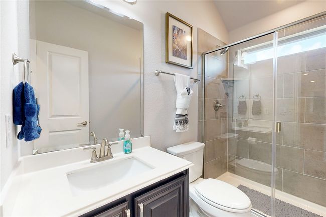 Bathroom featuring toilet, vanity, and a stall shower | Image 37