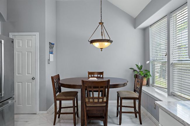 Dining room with plenty of natural light, light marble finish flooring, baseboards, and high vaulted ceiling | Image 9