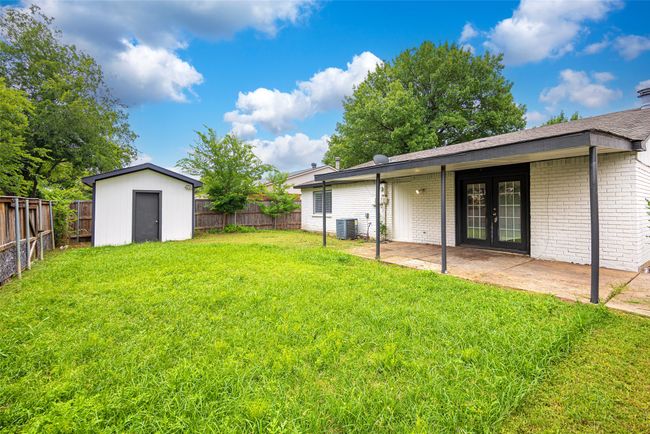 Fenced backyard with french doors, covered patio area, and a shed | Image 19