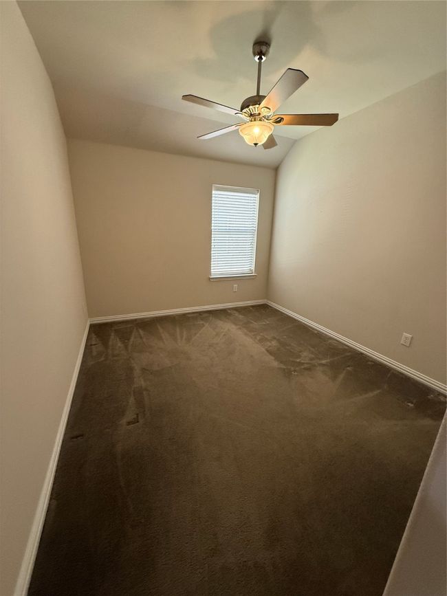 Spare room with baseboards, a ceiling fan, and dark colored carpet | Image 15