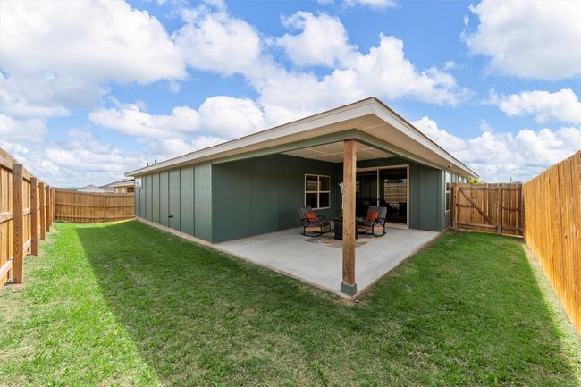 Rear view of property featuring a lawn, a patio area, and a fenced backyard | Image 25