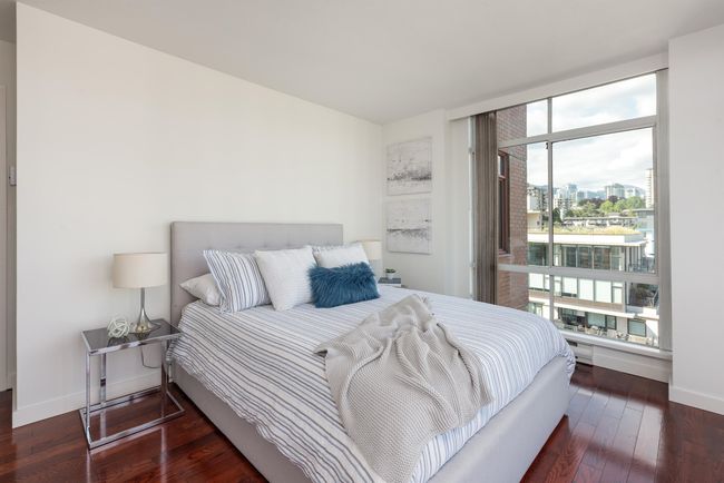 Bedroom featuring multiple windows, wood-type flooring, and a view of city | Image 30