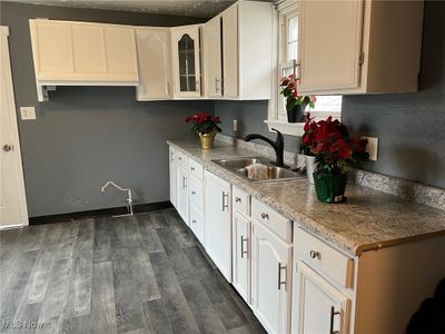 Kitchen with white cabinets, dark wood-type flooring, and sink | Image 3