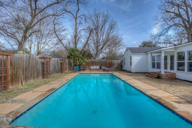 View of swimming pool with a fenced backyard, a fenced in pool, and french doors | Image 6