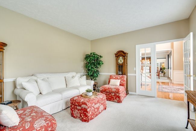 Carpeted living room featuring french doors | Image 18