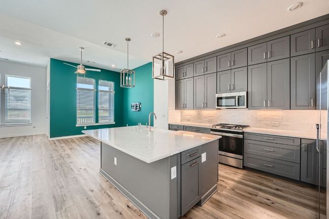 Kitchen with backsplash, gray cabinets, stainless steel appliances, and visible vents | Image 21