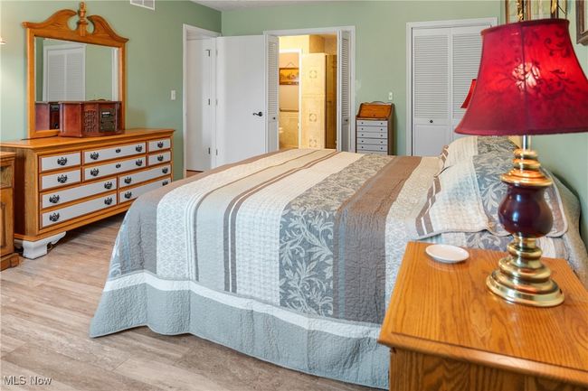 Bedroom with visible vents, ensuite bath, and wood finished floors | Image 20