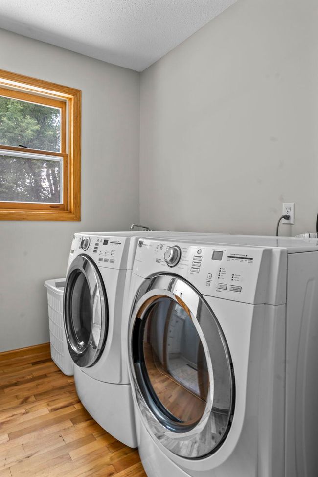 The main level also includes a practical laundry area with a Maytag front-loading washer and dryer and utility sink. | Image 11
