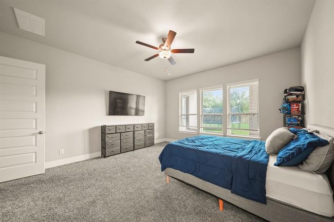 Spacious primary retreat featuring a ceiling fan, modern tones, and a walk-in closet. | Image 18