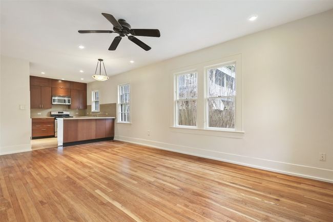 Kitchen with appliances with stainless steel finishes, light wood-style flooring, light countertops, a peninsula, and hanging light fixtures | Image 9