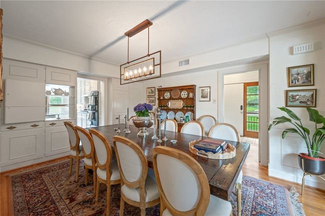 Dining space featuring crown molding, a chandelier, and light wood-style flooring | Image 9