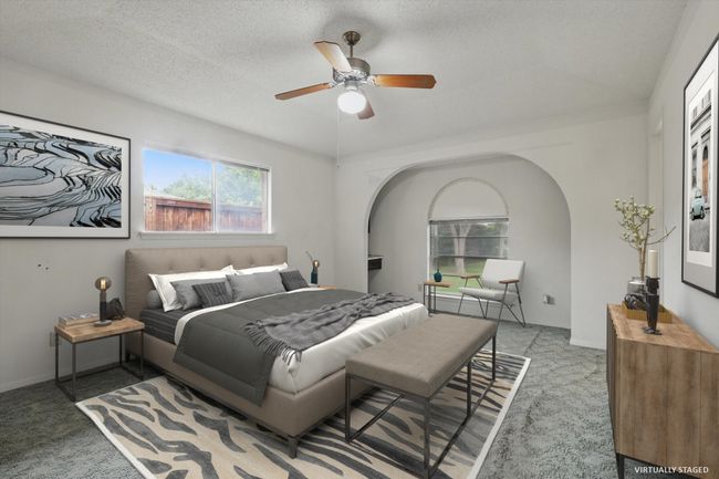 Carpeted bedroom with arched walkways and ceiling fan | Image 5