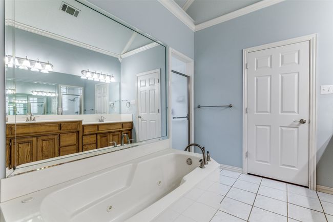 Full bath featuring ornamental molding, a tub with jets, double vanity, tile patterned floors, and a shower stall | Image 16