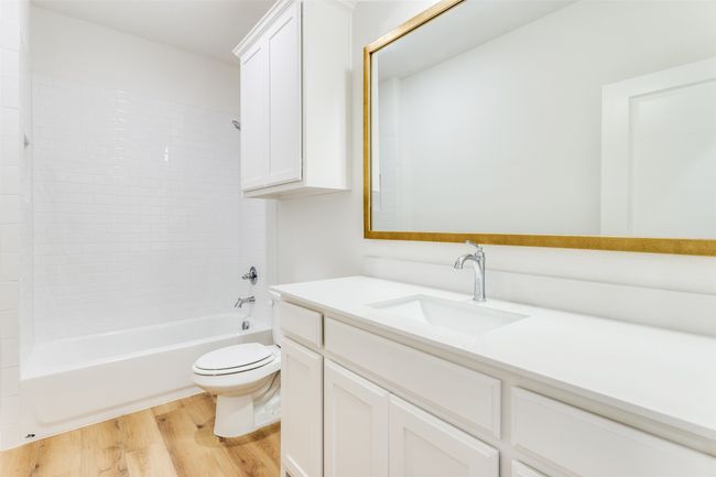 Full bathroom with shower / tub combination, oversized vanity, toilet, and wood-type flooring | Image 10