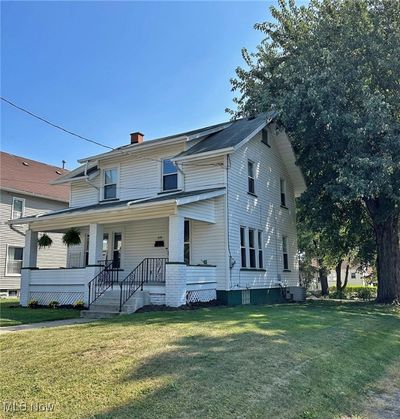 View of front of home with a front lawn, a porch, and central AC unit | Image 1