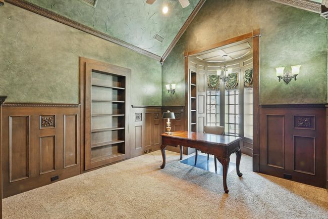 The home office includes a large walk in closet and a secret room with desk space behind the bookshelf. | Image 23