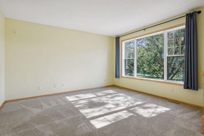 To the right as you enter, is the spacious living room with large windows. | Image 3