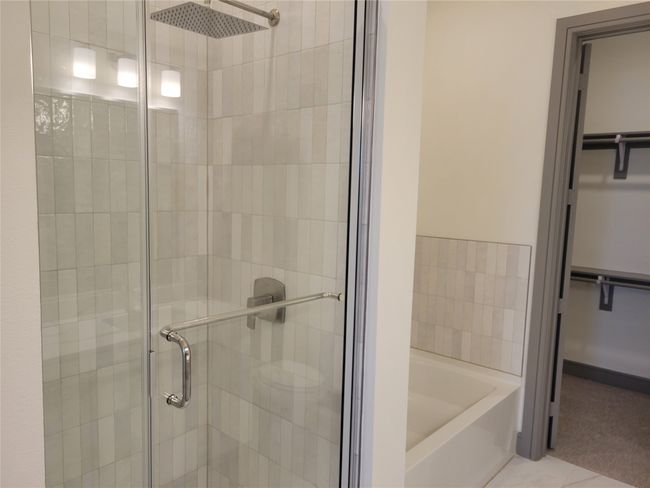 Full bath with a walk in closet, a shower stall, a garden tub, and tile patterned floors | Image 12