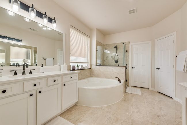 Bathroom featuring a stall shower, a garden tub, and vanity | Image 19