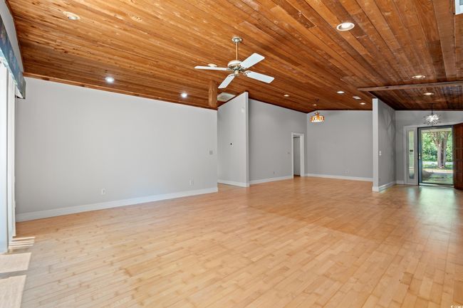 Unfurnished living room with wooden ceiling, light wood-style floors, recessed lighting, lofted ceiling, and a ceiling fan | Image 8
