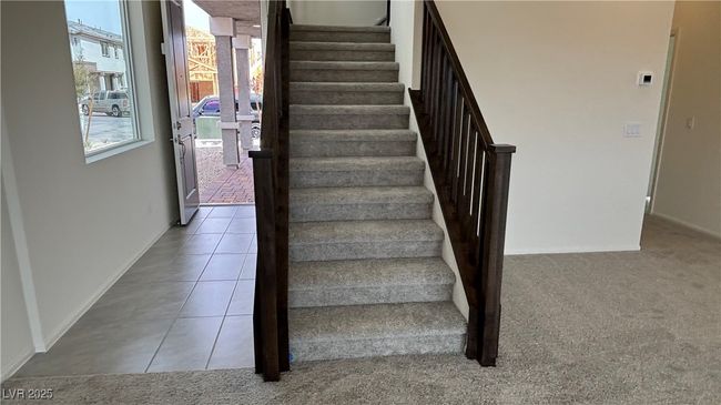 Stairs with tile patterned floors, carpet flooring, and baseboards | Image 8
