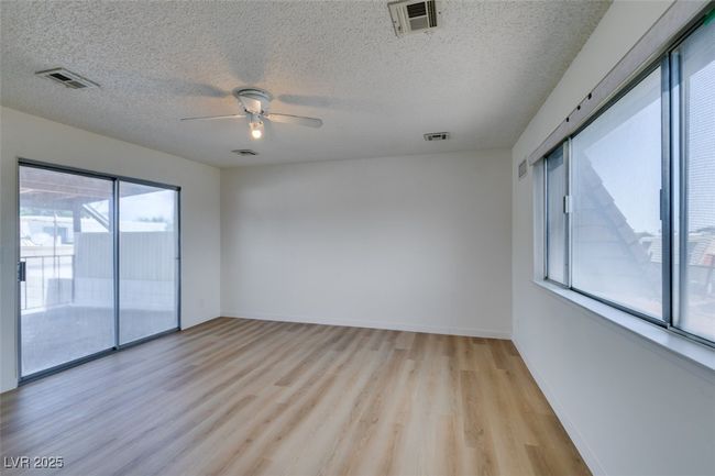 Spare room with light wood finished floors, ceiling fan, and a textured ceiling | Image 36