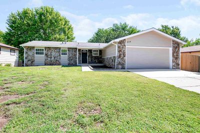 Ranch-style house with a front lawn and a garage | Image 1